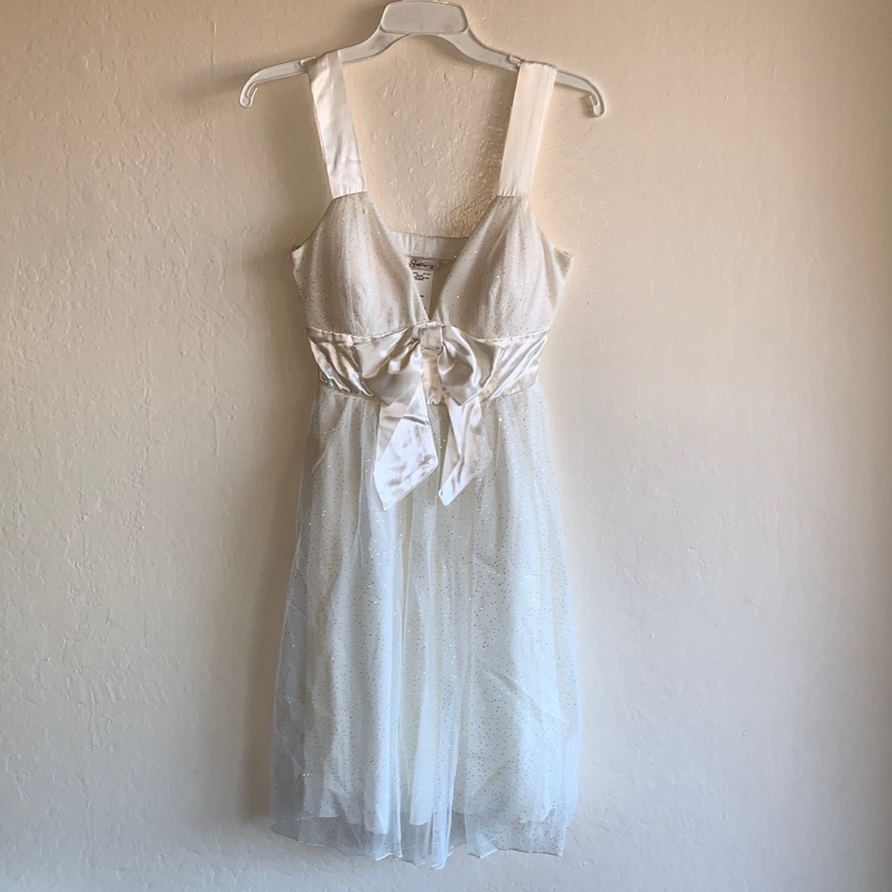 Glittery white dress with a bow.